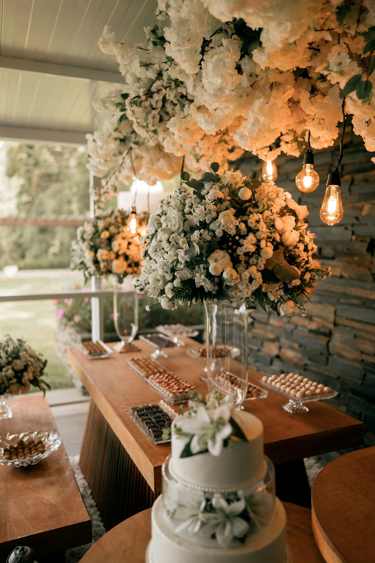 A wedding cake and dessert table decorated with flowers.